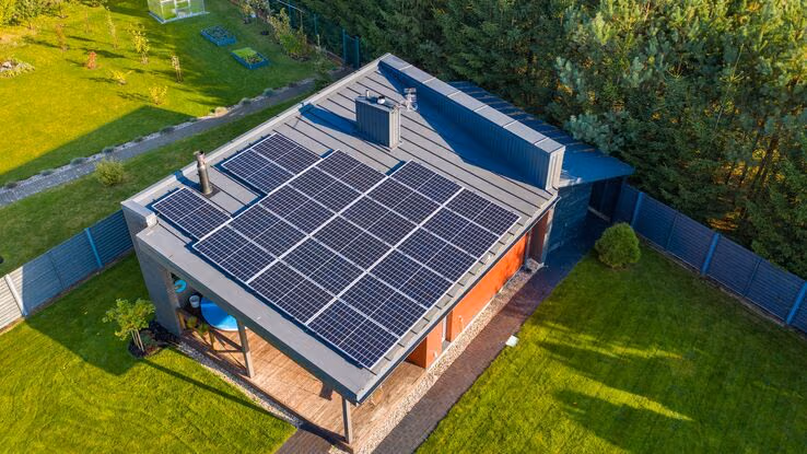 Eine Solaranlage auf dem Dach eines kleinen Hauses.