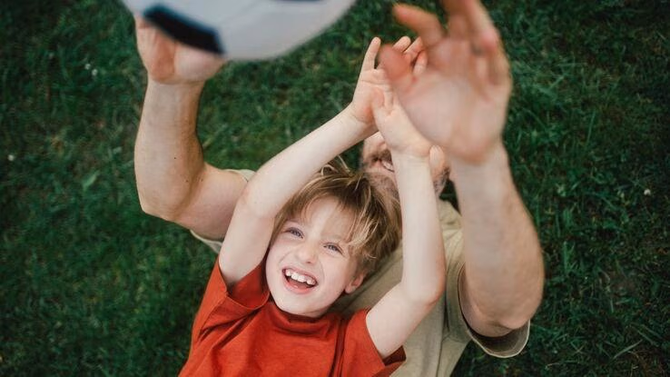 Vater und Sohn spielen Fußball.