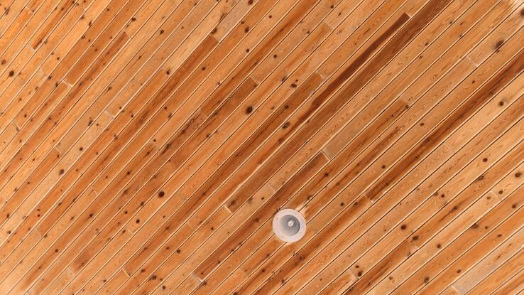 Auf dem Bild ist eine Holzdecke mit installierten Lichtern abgebildet.