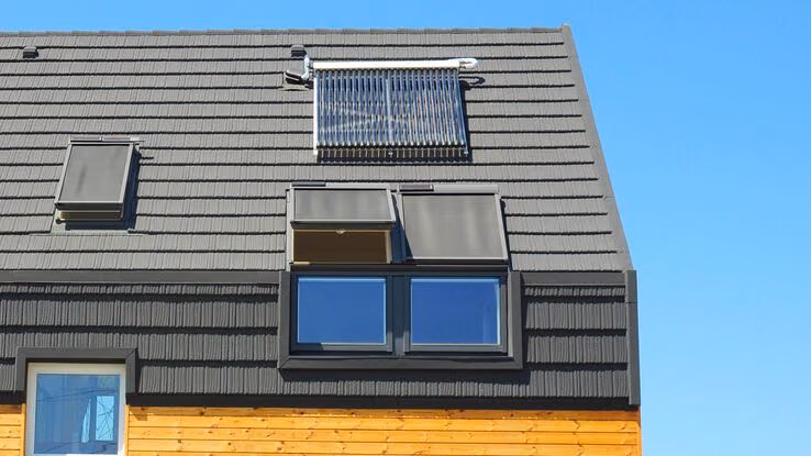 Abgebildet sind Sonnenkollektoren auf dem Dach eines Hauses.
