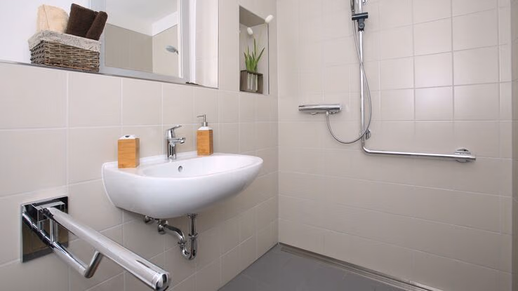 Es ist ein Badezimmer mit barrierefreiem Zugang zur Dusche abgebildet.