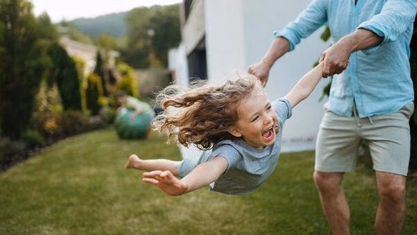 Vater und Kind haben Spaß im Garten und spielen.