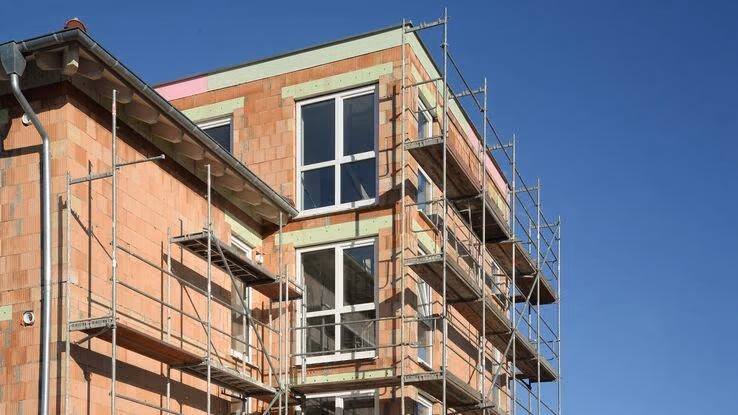Abgebildet ist ein Haus im Bau, das mit recycelten Ziegelsteinen errichtet wird.