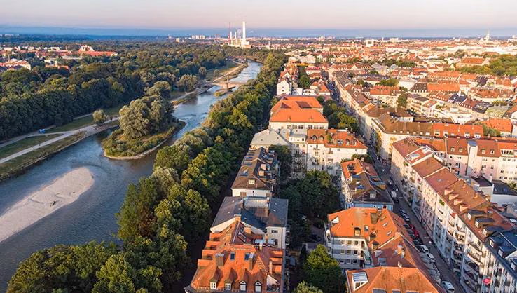 Die Isar fließt an einem ruhigen Sommermorgen durch München – Luftaufnahme.