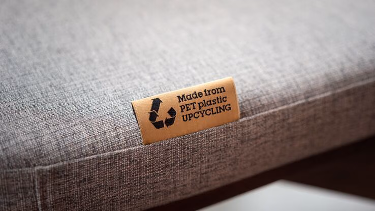 Es ist eine Upcycling-Kennzeichnung von einem Polster mit einem eingenähten Zettel zu sehen.