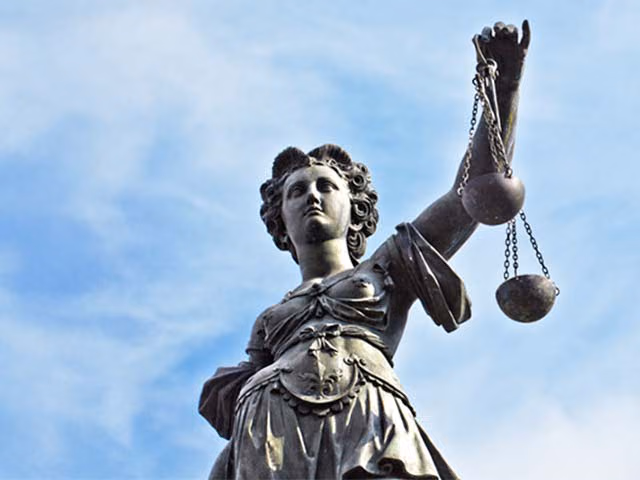 Eine Statue der Justitia steht symbolisch für das Thema Steuern und Recht beim Immobilienkauf.