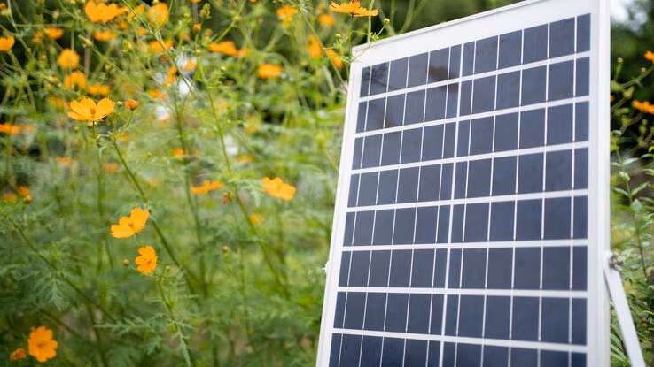 Eine kleine Solaranlage steht im Garten auf der Wiese.