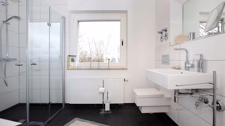 Auf dem Bild ist ein Badezimmer nach der Sanierung mit begehbarer Dusche abgebildet.