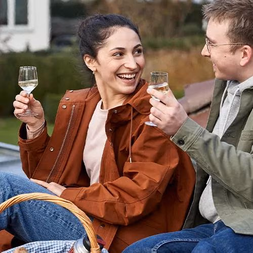 Ein Pärchen feiert ihre eigene Immobilie mit einem Glas Sekt.