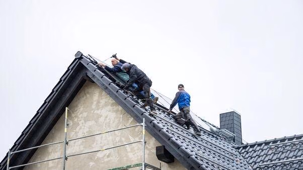 Arbeiter modernisieren ein Hausdach.