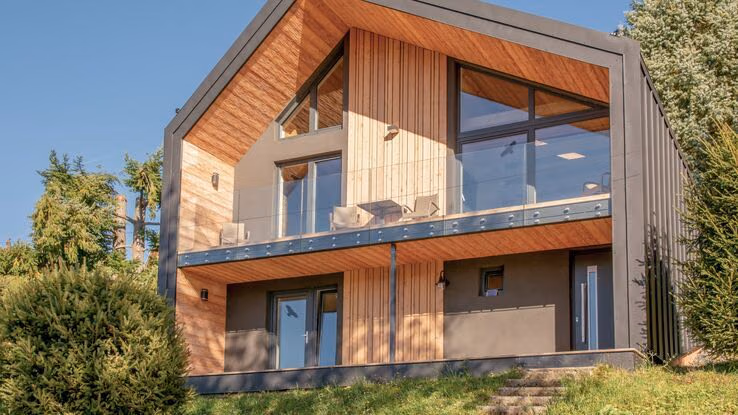 ußerdem besitzt das Haus eine Terasse und einen großen Balkon. Der erste Stock des Hauses hat sehr große Fenster.