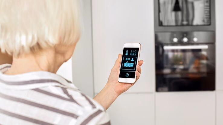 Eine ältere Frau hat ihr Haus umbauen lassen und nutzt Smart Home Technologie.