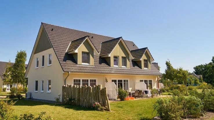 Auf dem Bild ist ein Reihenhaus mit den dazugehörigen Gärten abgebildet.