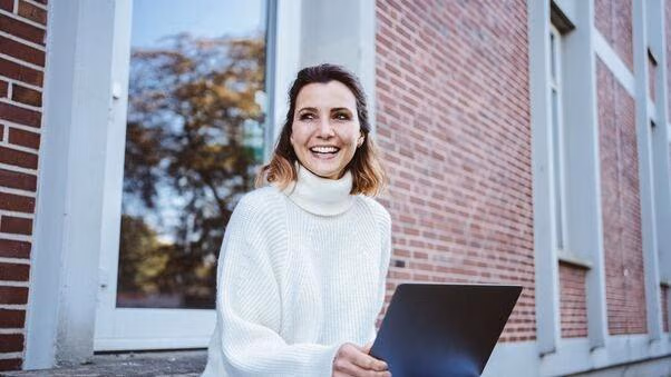 Eine Frau sitzt an ihrem Laptop und arbeitet.