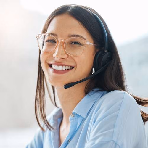 Eine Frau lächelt in die Kamera und hat ein Headset auf dem Kopf.