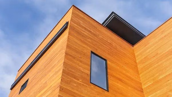 Moderne Architektur mit klaren Linien, Holzfassade und großflächigen Fensterelementen.