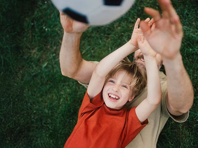 Vater und Sohn spielen Fußball.