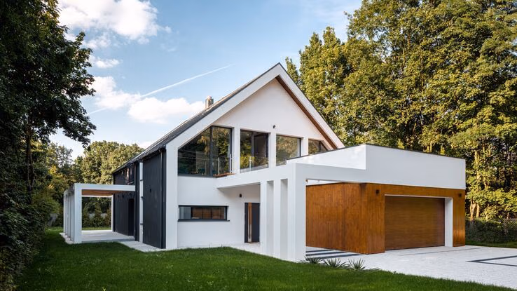 Zu sehen ist ein modernes weißes Einfamilienhaus mit einer Garage.