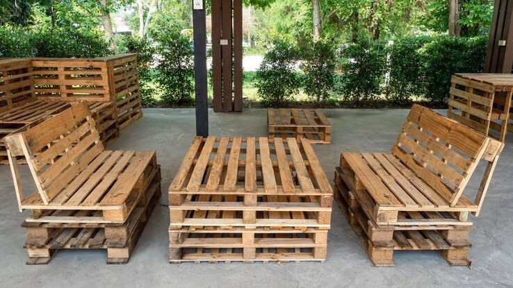 Es sind Sitzmöbel für den Garten oder die Terrasse aus alten Holzpaletten zu sehen.