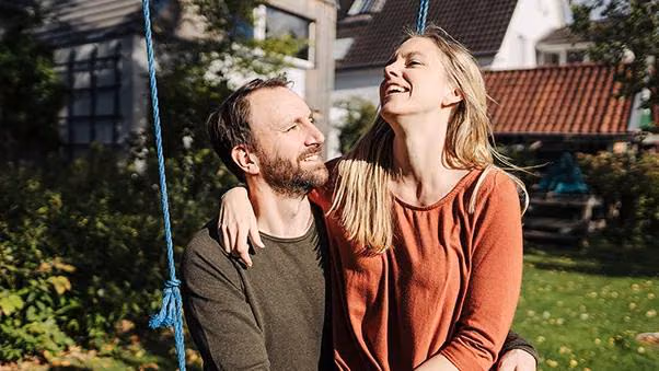 Ein Pärchen sitzt im Garten auf der Schaukel.
