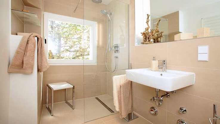 Ein Badezimmer mit altersgerechter Dusche und Hocker.