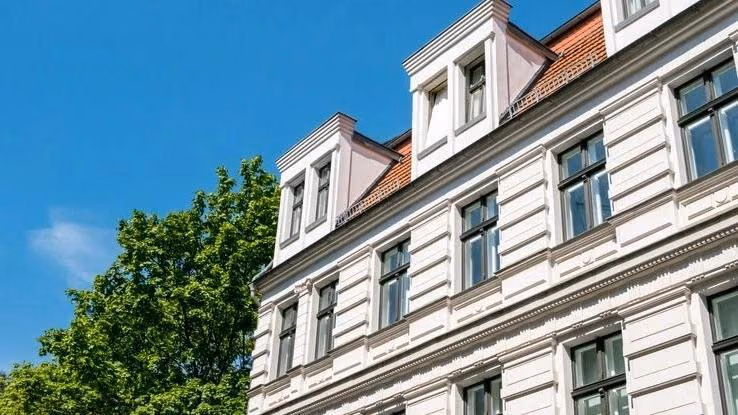 Das Bild zeigt ein elegantes, mehrstöckiges, weißes Gebäude mit klassischer Architektur.