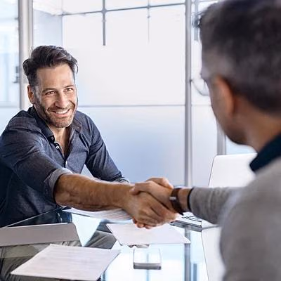 Ein Mann schüttelt seinem Finanzierungsberater die Hand.